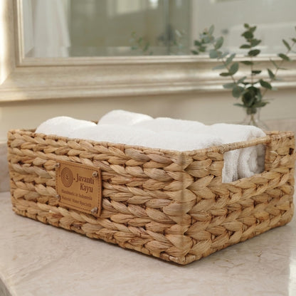 Small basket on a bathroom counter with folded white towels