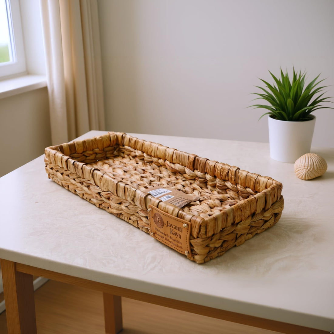 Slim water hyacinth tray styled on a console table beside a potted plant