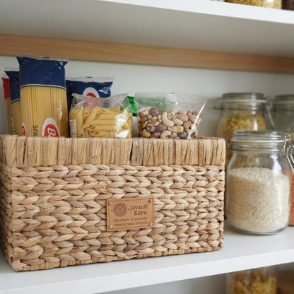 Medium basket on a pantry shelf holding dry goods beside storage jars