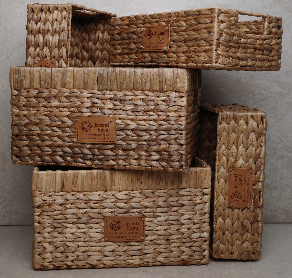 Set of woven baskets with leather labels on a gray background